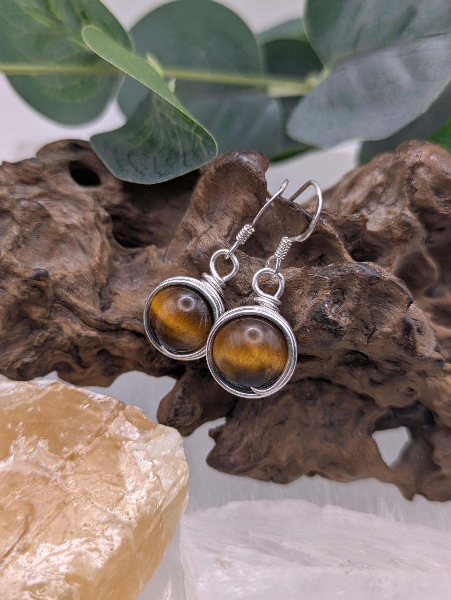Silver earrings featuring round Tiger’s Eye gemstones with golden-brown chatoyancy.