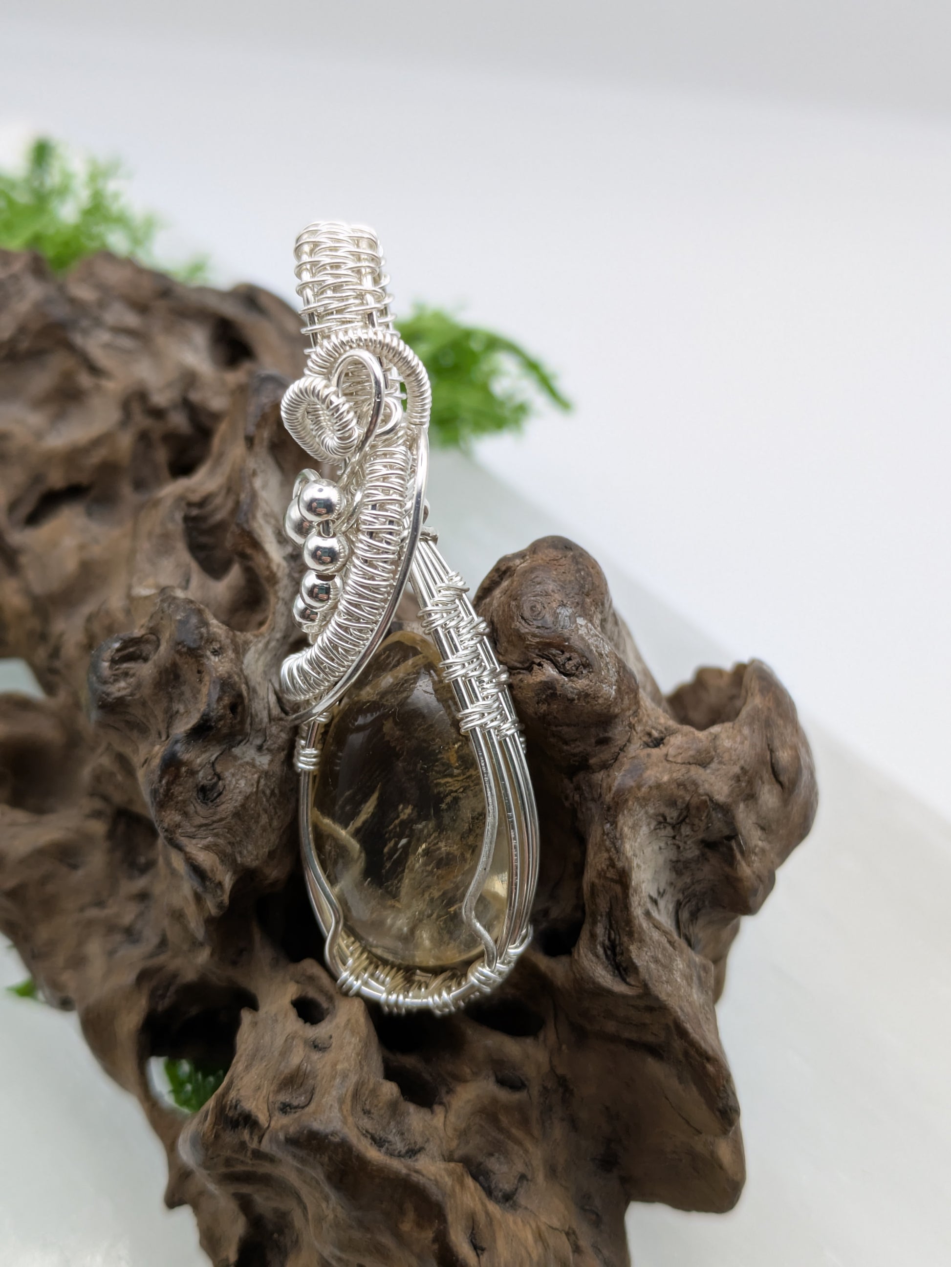 Hand-wrapped Citrine pendant in sterling silver, glowing with golden hues and artisanal detail