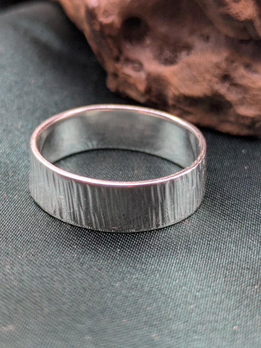 <img src="bark-effect-ring.jpg" alt="Handcrafted 6mm sterling silver ring with bark-inspired hammered texture, a bold and earthy statement band made from recycled 925 silver">