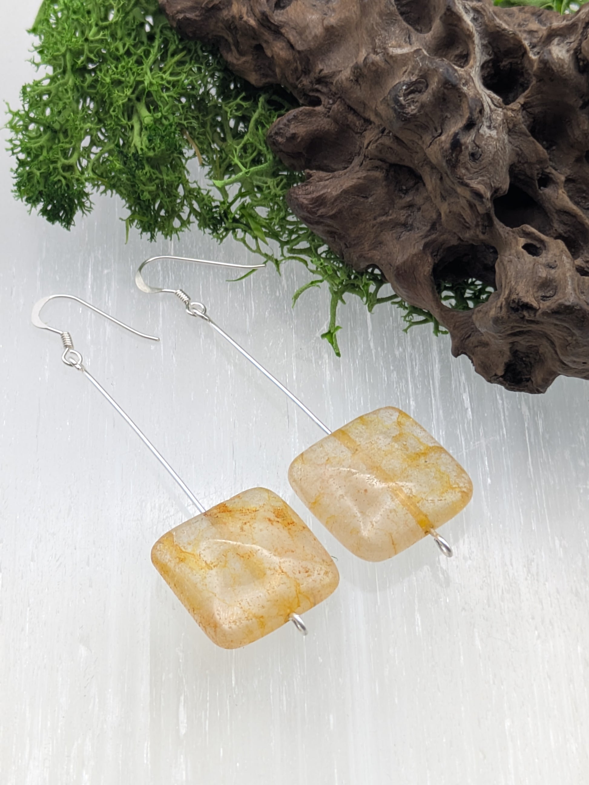 Hand-wrapped Citrine earrings in silver, glowing with golden warmth and elegant craftsmanship