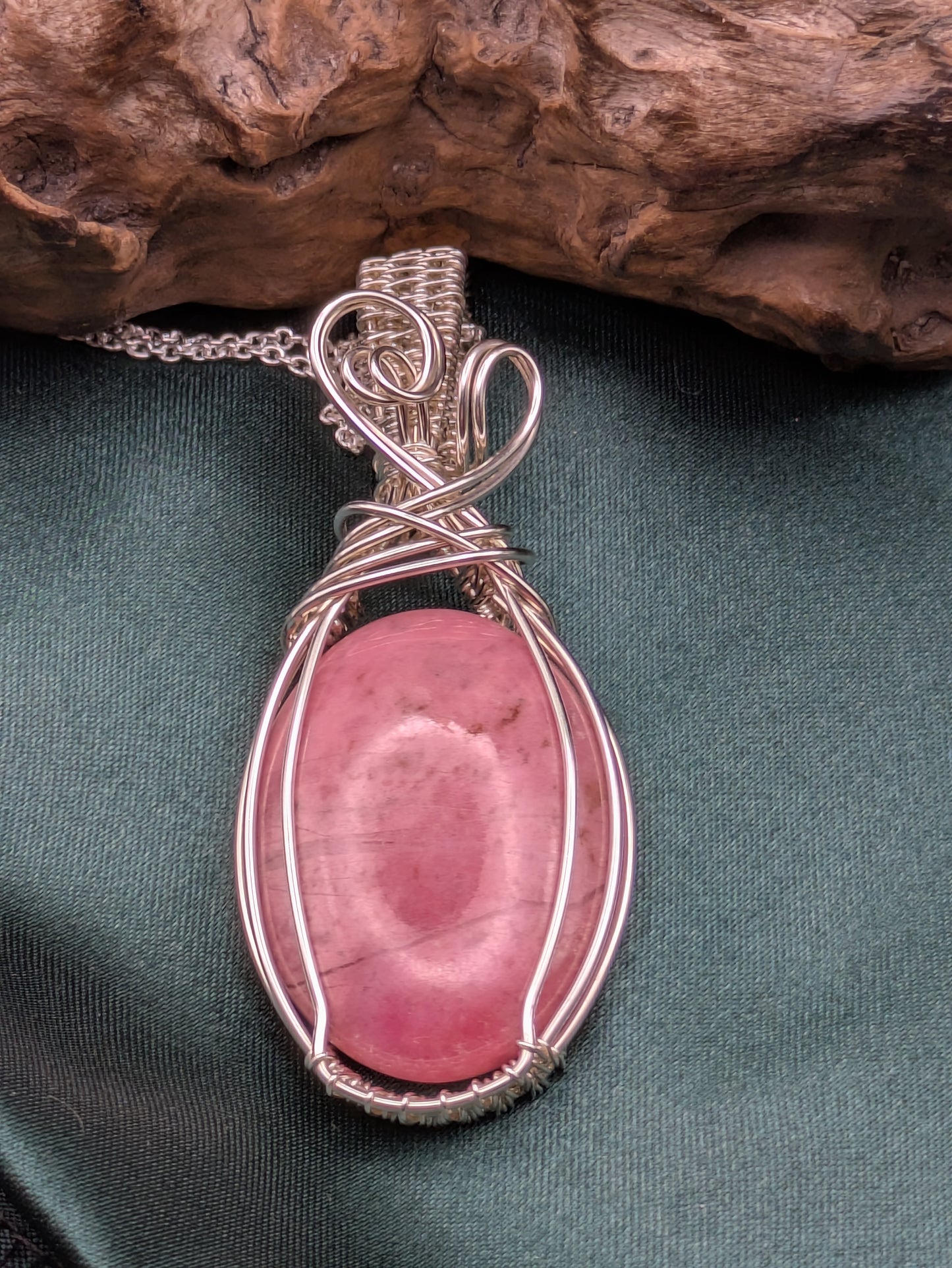 Dusky pink rhodonite pendant wrapped in recycled silver echoing summer blooms and grounded elegance
