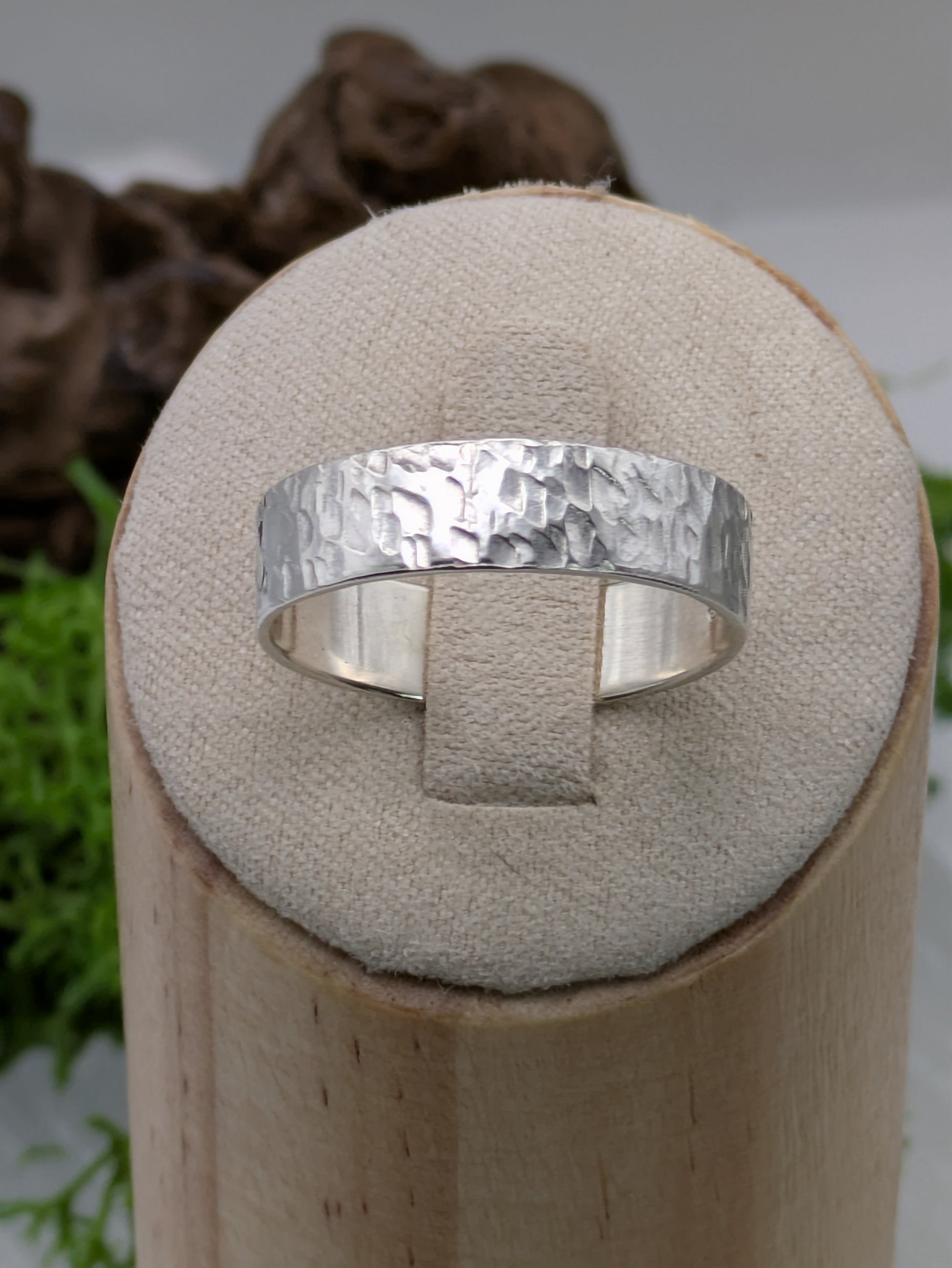Fully hallmarked Textured Sterling Silver ring on a piece of driftwood with greenery