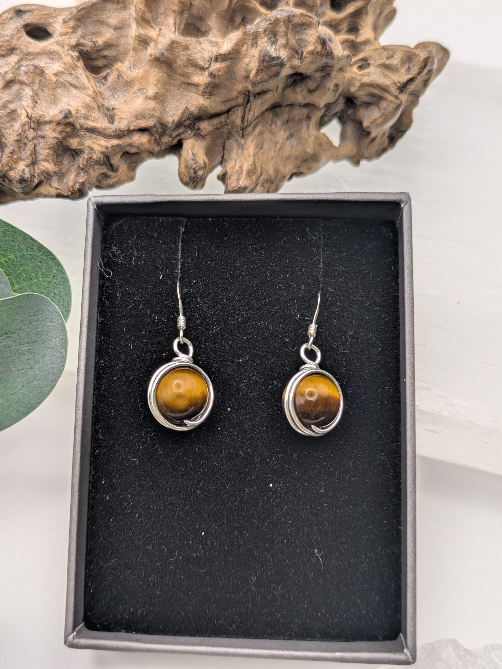 Silver earrings featuring round Tiger’s Eye gemstones with golden-brown chatoyancy.