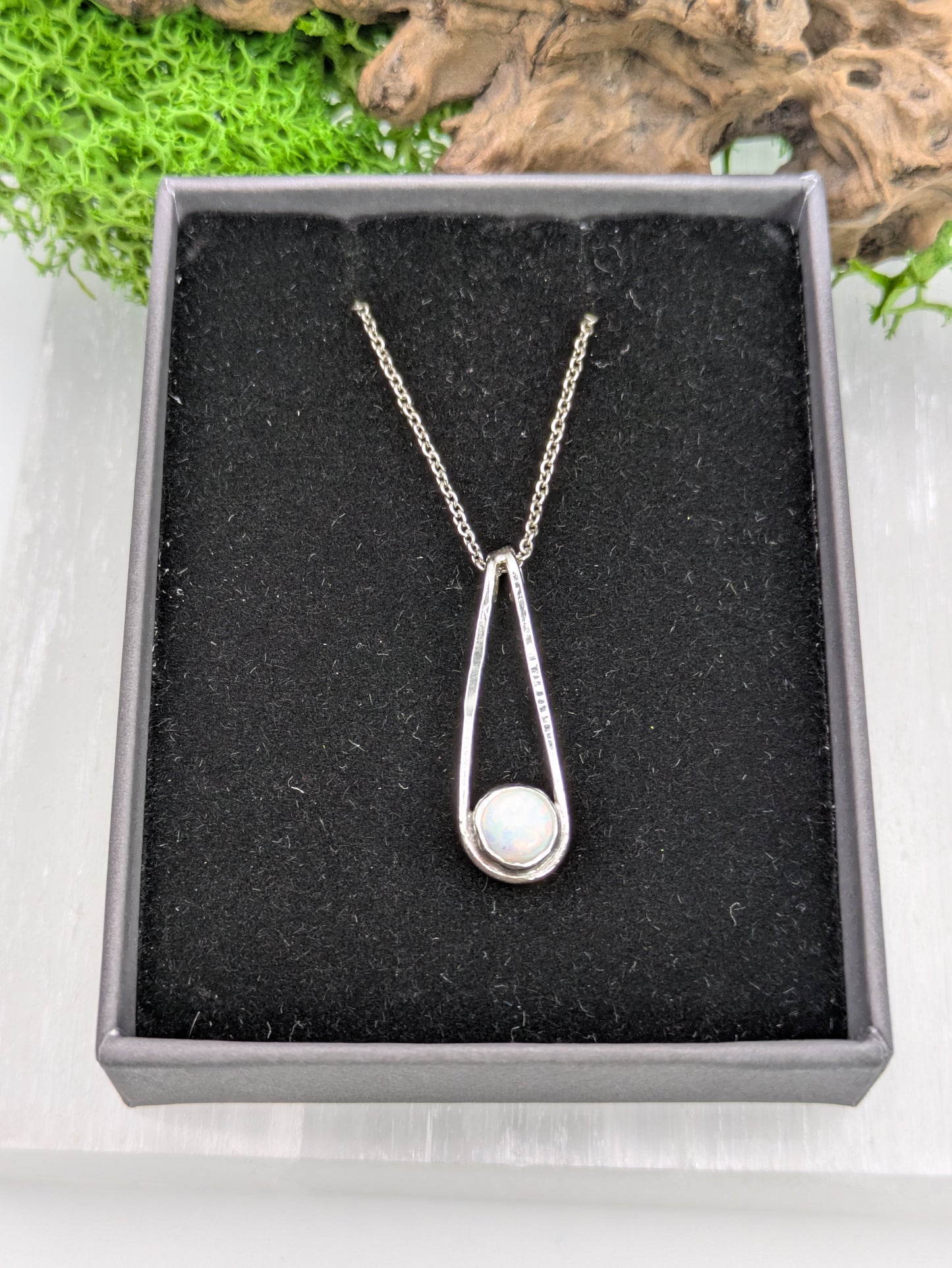 Sterling silver pendant in a Teardrop shape with a glowing Kyocera opal in soft pink and blue tones, fully hallmarked and displayed on a neutral background.