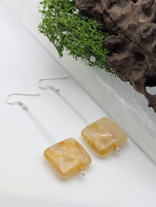 Hand-wrapped Citrine earrings in silver, glowing with golden warmth and elegant craftsmanship