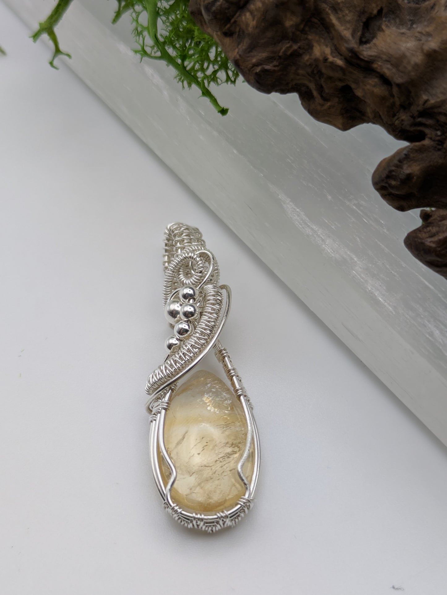 Hand-wrapped Citrine pendant in sterling silver, glowing with golden hues and artisanal detail
