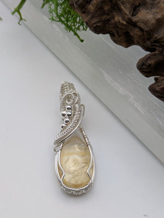 Hand-wrapped Citrine pendant in sterling silver, glowing with golden hues and artisanal detail