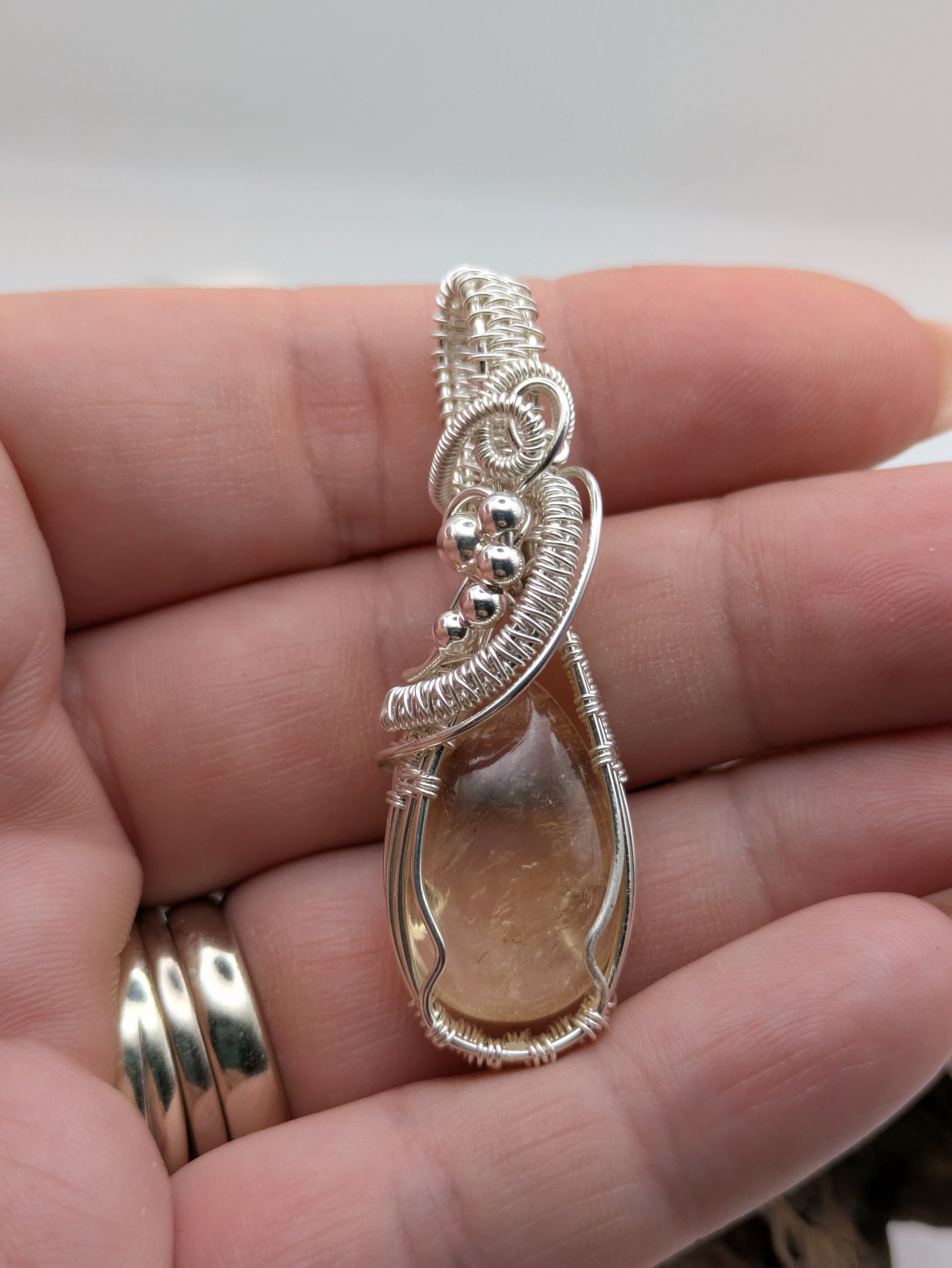 Hand-wrapped Citrine pendant in sterling silver, glowing with golden hues and artisanal detail