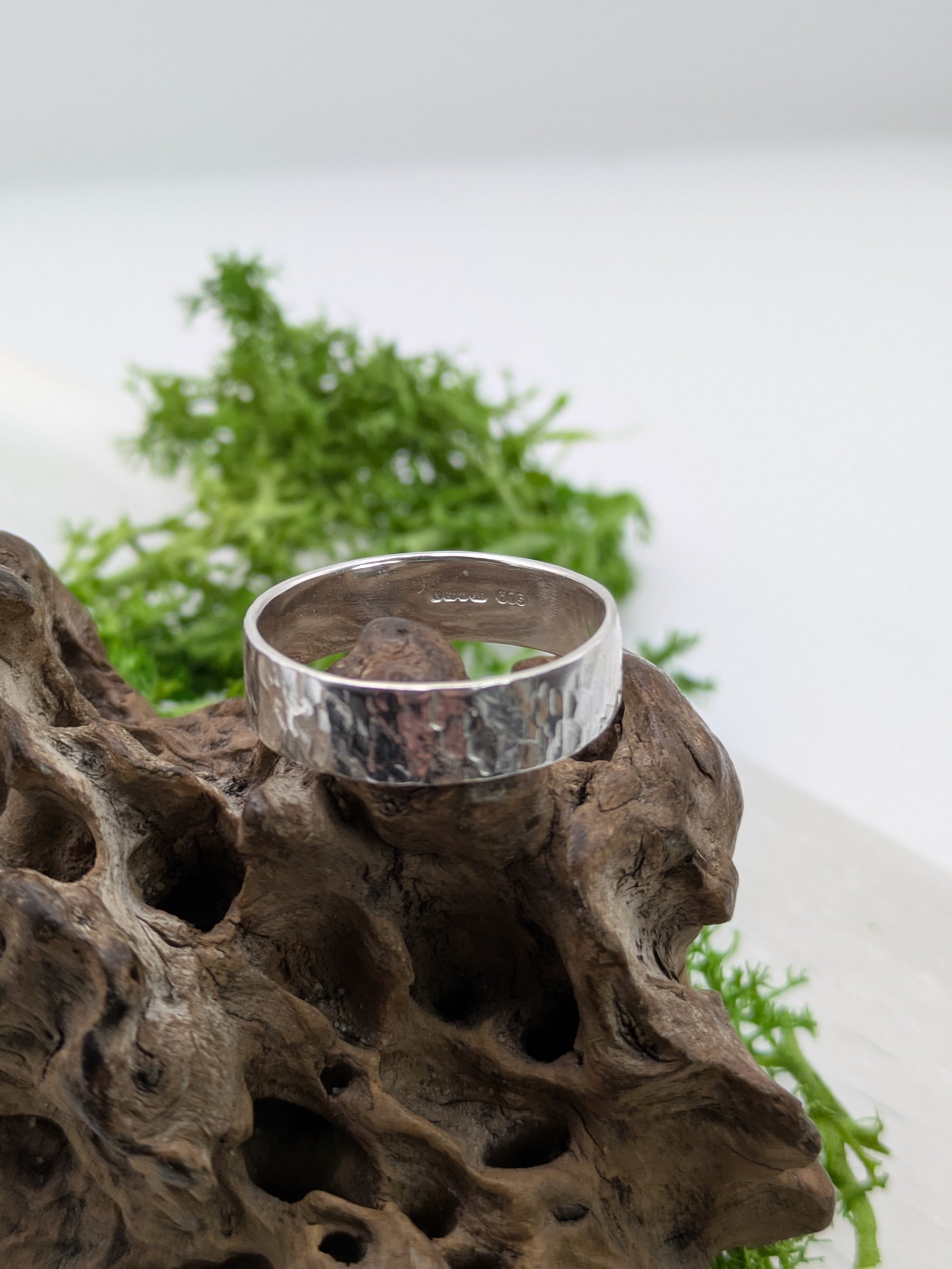 Fully hallmarked Textured Sterling Silver ring on a piece of driftwood with greenery