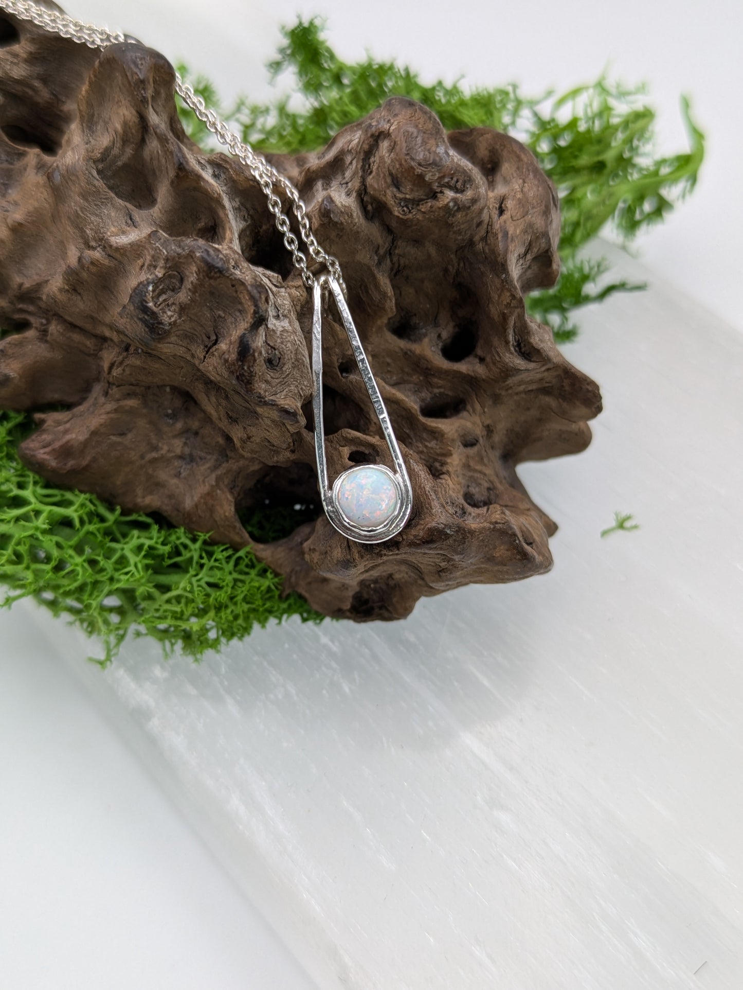 Sterling silver pendant in a Teardrop shape with a glowing Kyocera opal in soft pink and blue tones, fully hallmarked and displayed on a neutral background.