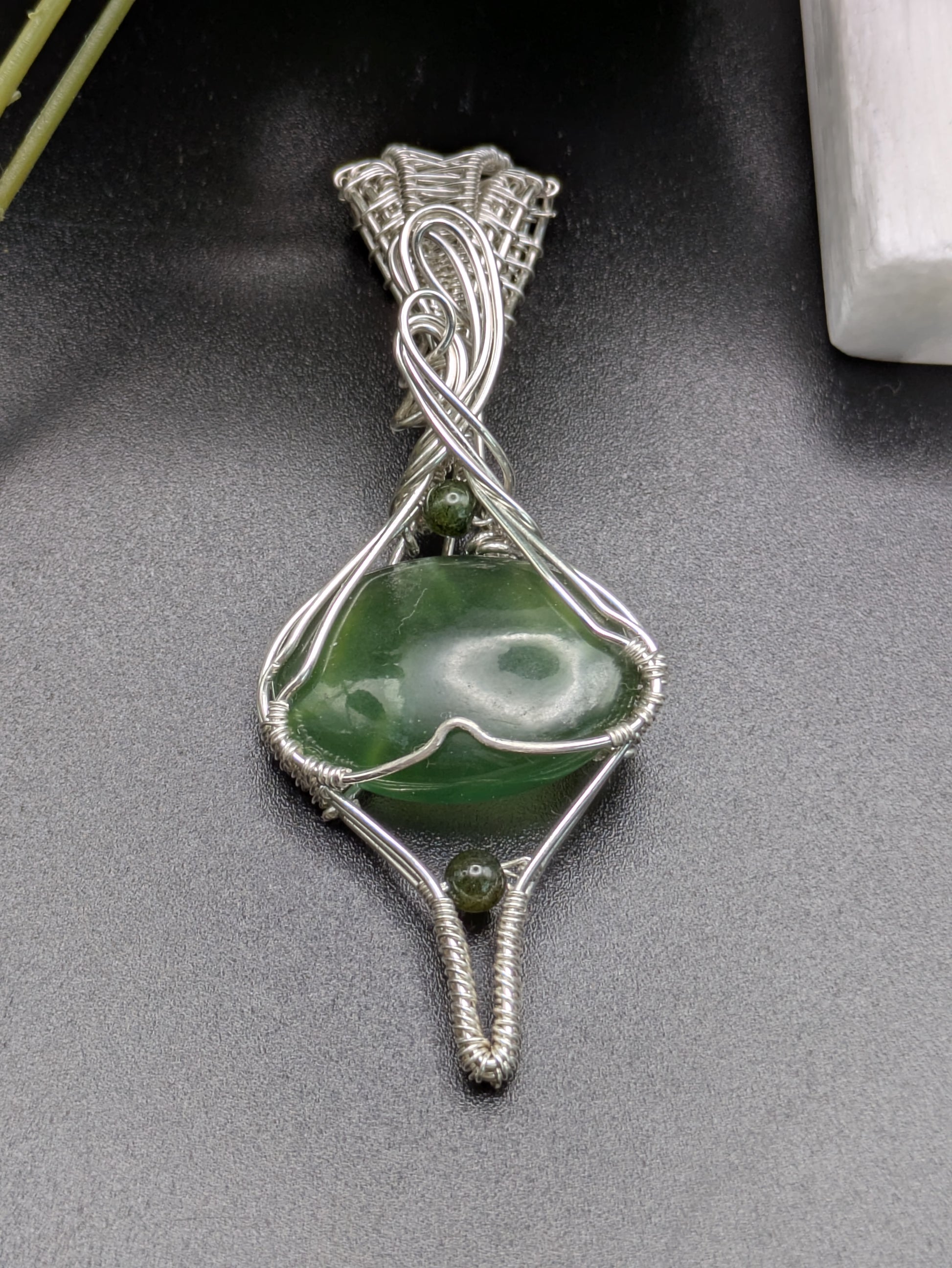 <img src="indonesian-jade-pendant.jpg" alt="Handmade Indonesian jade pendant wrapped in recycled sterling silver, a unique statement crystal necklace inspired by nature">
