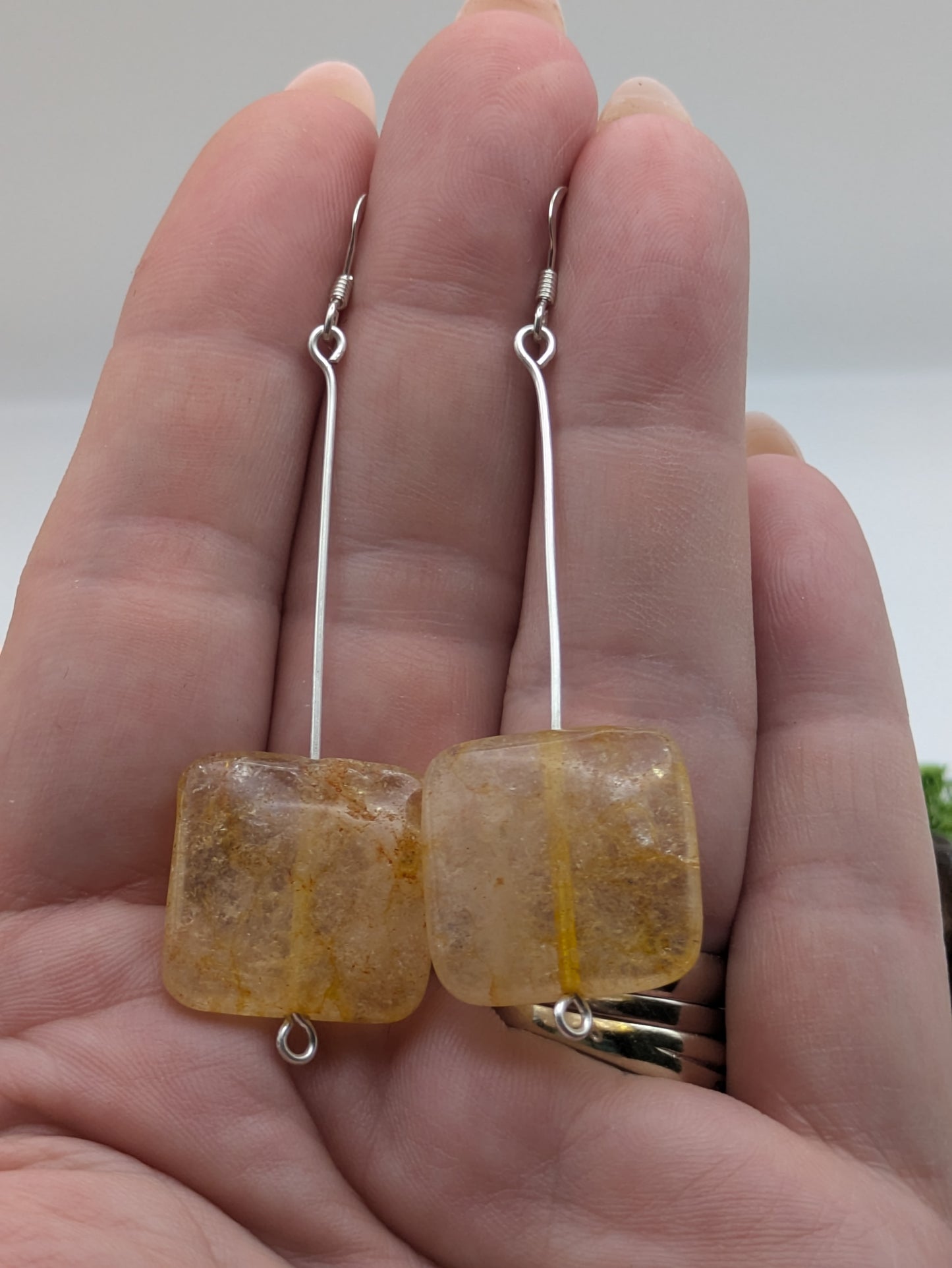 Hand-wrapped Citrine earrings in silver, glowing with golden warmth and elegant craftsmanship