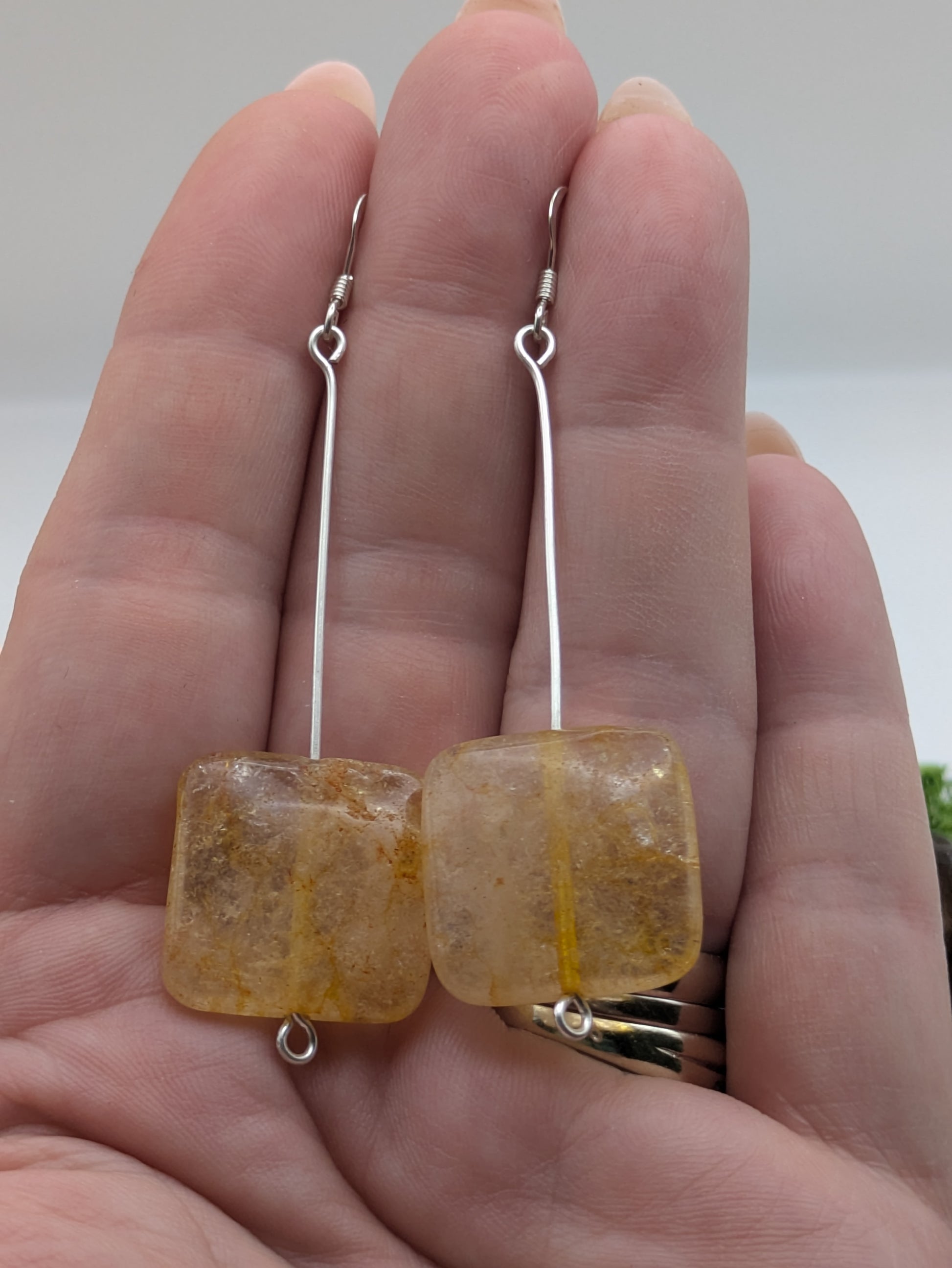 Hand-wrapped Citrine earrings in silver, glowing with golden warmth and elegant craftsmanship