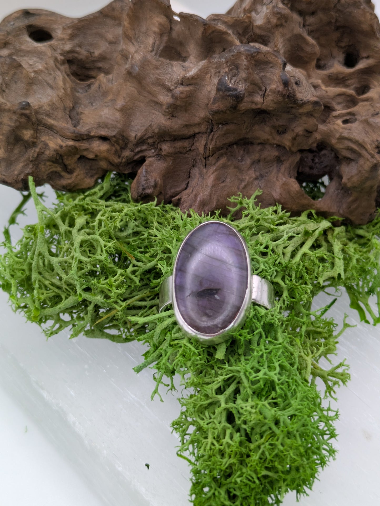 Sterling silver ring featuring a luminous purple labradorite with violet and silver flashes, fully hallmarked and photographed on a soft neutral background.