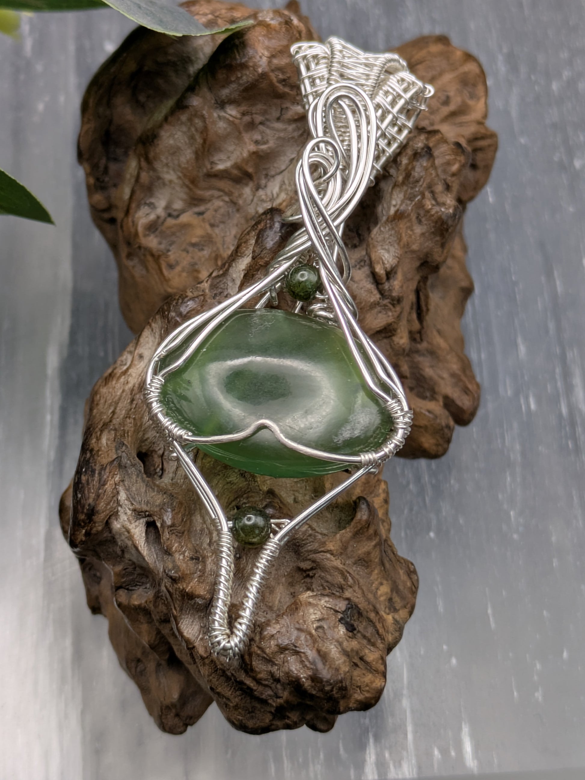 <img src="indonesian-jade-pendant.jpg" alt="Handmade Indonesian jade pendant wrapped in recycled sterling silver, a unique statement crystal necklace inspired by nature">