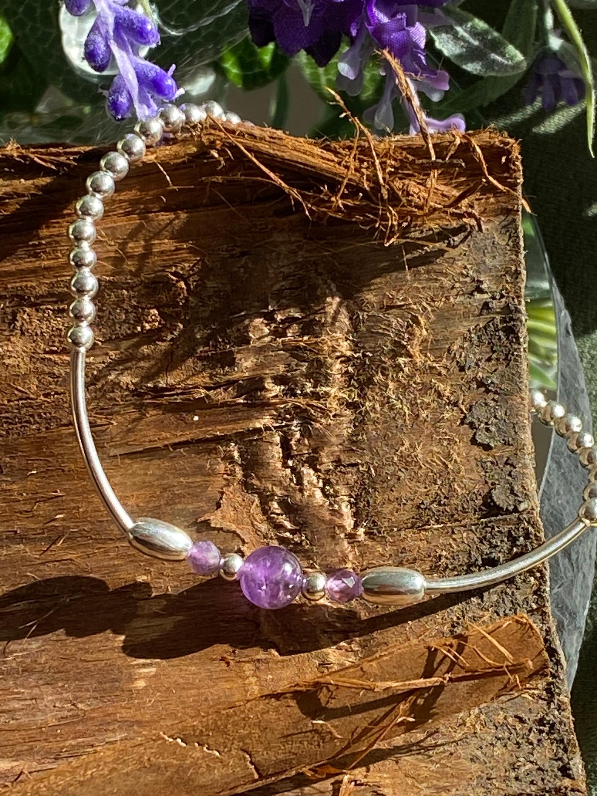 <img src="amethyst-bracelet.jpg" alt="Handmade amethyst bracelet with sterling silver beads, a calming purple crystal design for February birthdays and spiritual protection">
